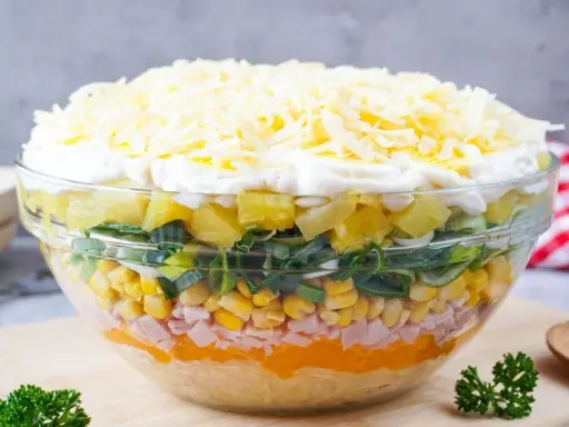 Schichtsalat Rezept: Bunter Schichtsalat in Glas, mit Schinken, Mais, Lauch, Ananas, Ei und Käse.