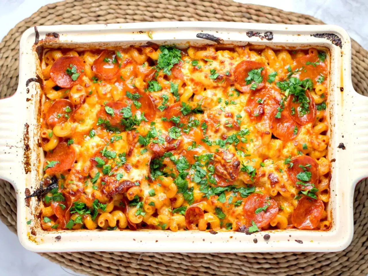 Herzhafter Nudelauflauf mit geschmolzenem K&auml;se und Pepperoni, garniert mit Petersilie. Ein tolles Beispiel f&uuml;r einfache Auflauf Rezepte.