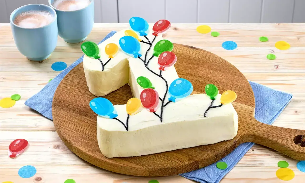 Ein wei&szlig;er Kuchen in Form der Zahl 1, dekoriert mit bunten Luftballons. Perfekt als Geburtstagskuchen f&uuml;r Kinder, um den ersten Geburtstag zu feiern.