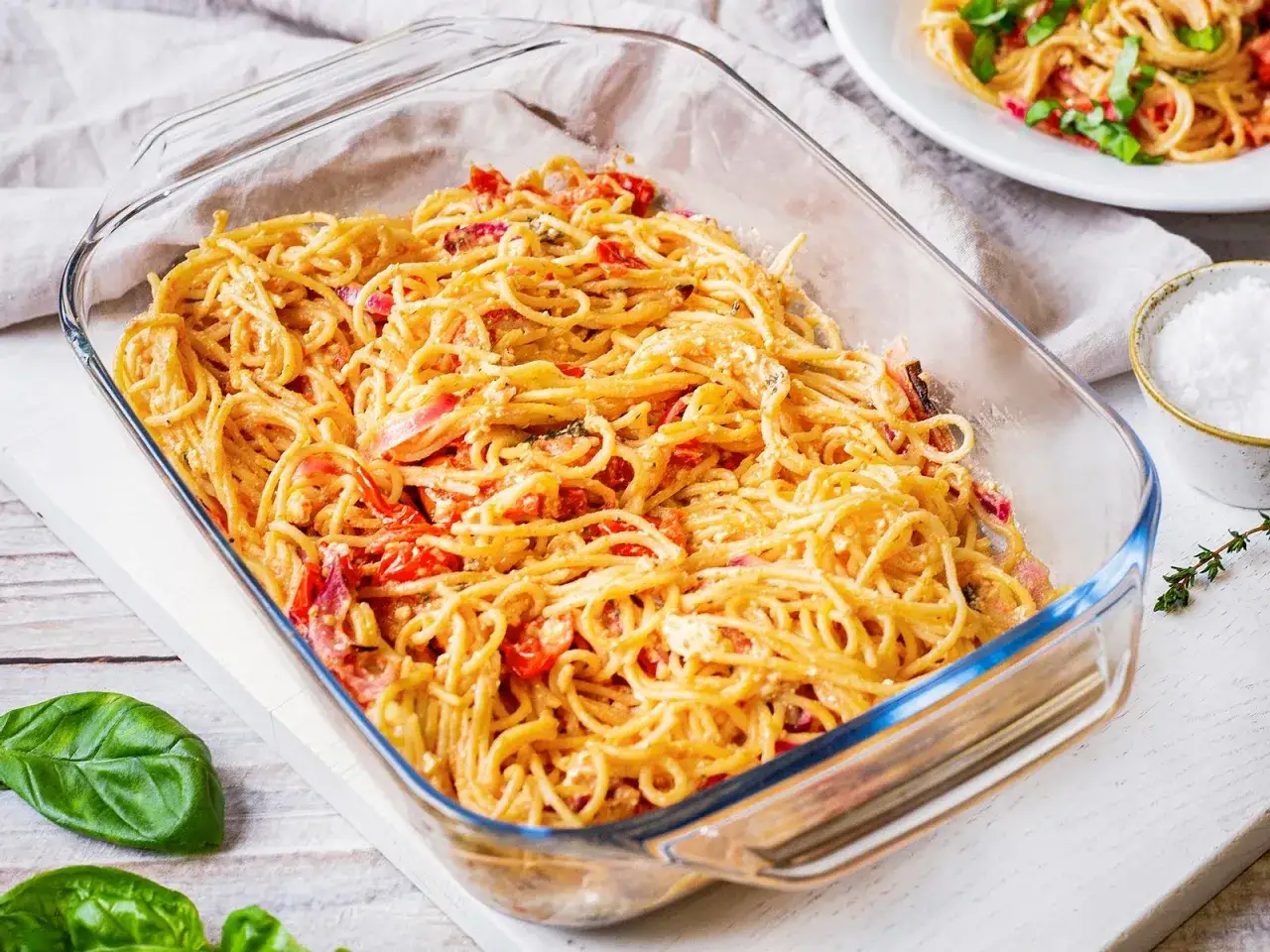 Fertige One Pot Pasta im Ofen, cremige Spaghetti mit Tomaten und Kr&auml;utern in einer Auflaufform.