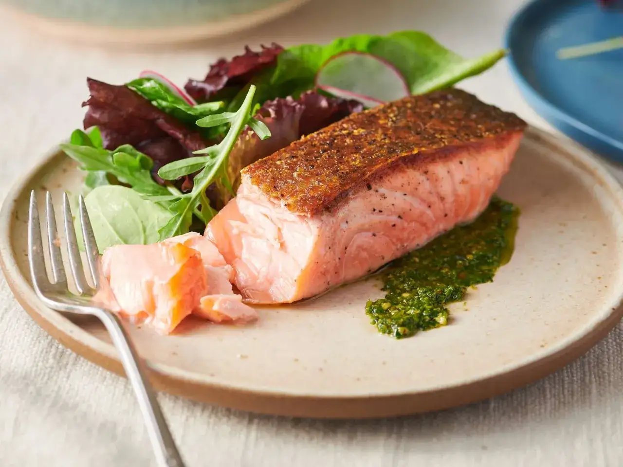 Perfekt gebratener Lachs mit knuspriger Kruste, serviert mit frischem Salat und Kr&auml;utersauce. Ein Genuss f&uuml;r alle Sinne!