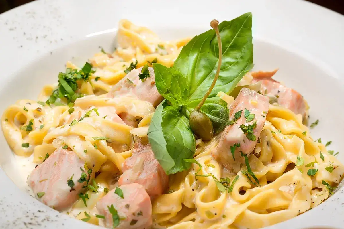 Cremige Tagliatelle al Salmone mit frischem Basilikum und Kapern. Ein Genuss f&uuml;r Feinschmecker.