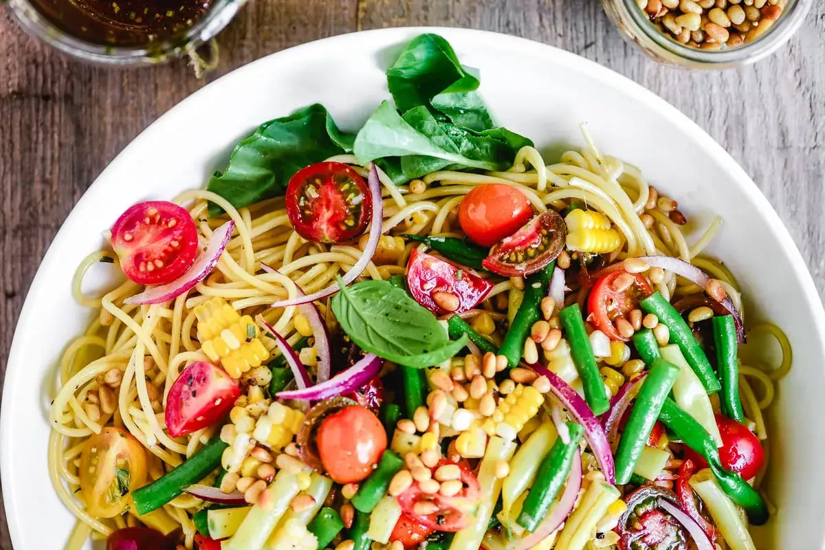 Bunter Spaghetti-Salat mit Tomaten, Mais, gr&uuml;nen Bohnen und Pinienkernen &ndash; perfekt als leichter Spaghetti Salat zum Grillen.
