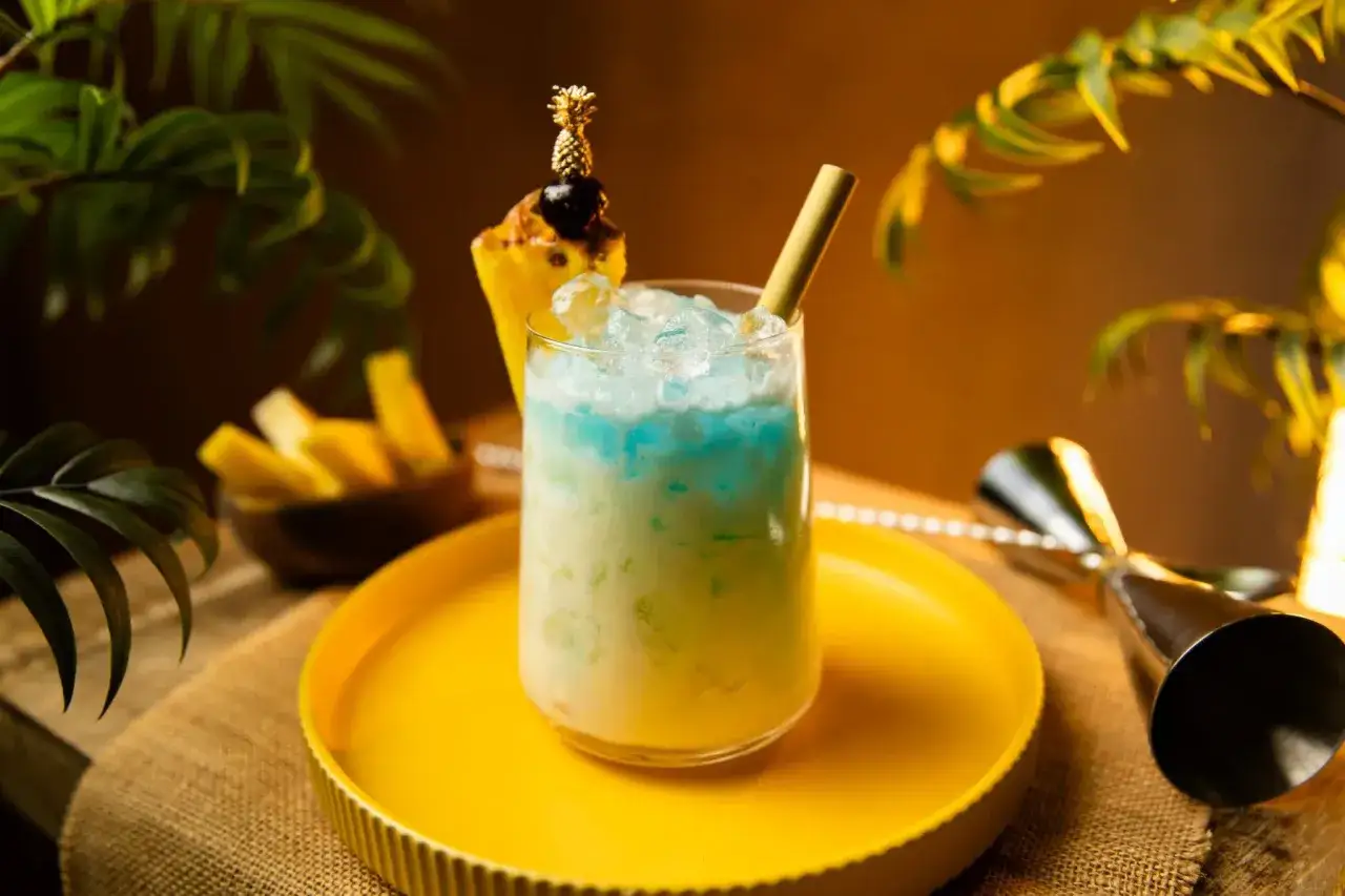 Erfrischender Swimmingpool Cocktail mit Ananas-Garnitur und Eis, bereit f&uuml;r den Sommer.