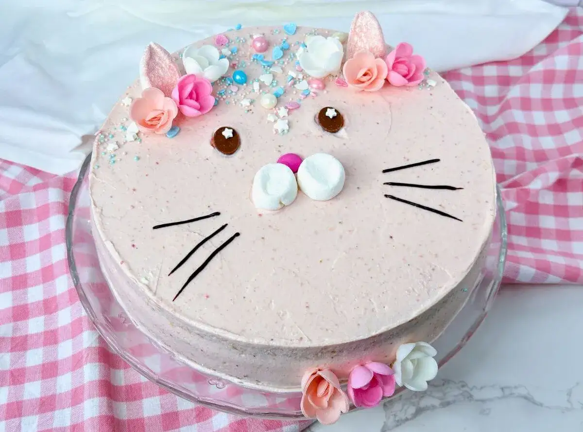 Ein s&uuml;&szlig;er Geburtstagskuchen f&uuml;r Kinder, dekoriert als Katzen-Gesicht mit Marshmallows, Schokoladenaugen und bunten Streuseln.