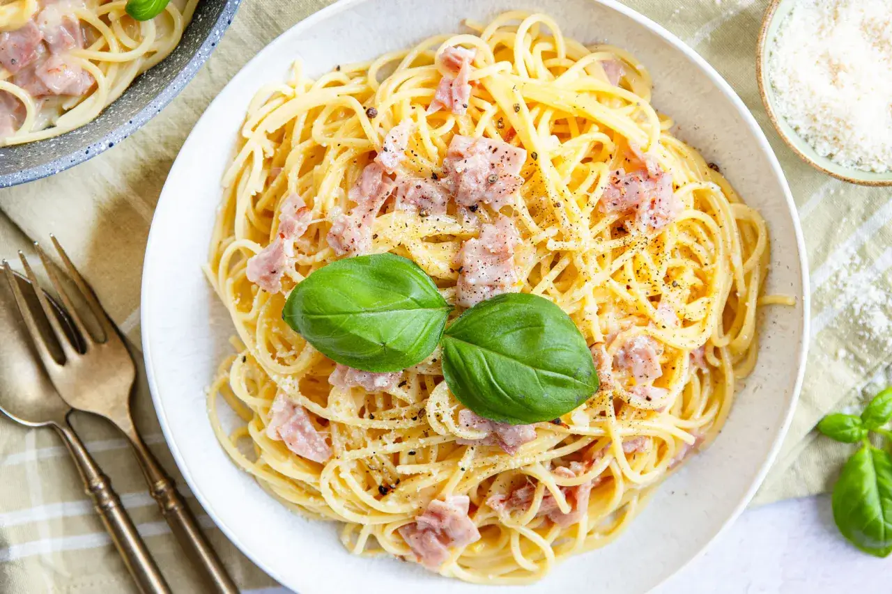 Eine cremige Carbonara mit Spaghetti, Speckw&uuml;rfeln und frischem Basilikum. Perfekt f&uuml;r ein schnelles Abendessen.